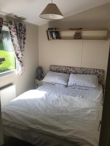 1 dormitorio con 1 cama en una habitación pequeña en Stunning deluxe 3 bedroomed caravan with CH, DG and decking. en Blackpool