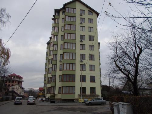 a tall green building with cars parked in a parking lot at 1-комнатная квартира-студия Люкс Элитный дом-2016 Центр in Truskavets