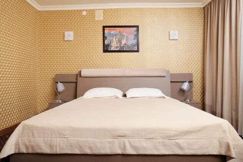 1 dormitorio con 1 cama grande con sábanas blancas en Green City Hotel, en Mykolaiv