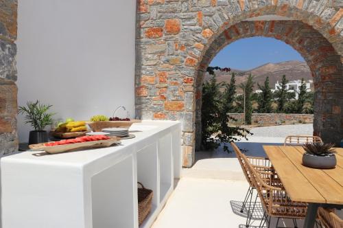 una cocina con un arco y una mesa con fruta. en The Nine Graces - Kastraki Villas with Private Swimming Pool, en Kastraki Naxou