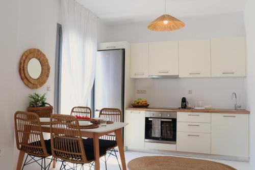 a kitchen with a table and chairs in a kitchen at The Nine Graces - Kastraki Villas with Private Swimming Pool in Kastraki Naxou