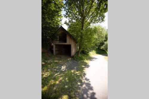a small building is next to a road at La Harde 31 pers Malmedy, vue, wellness, jardin in Malmedy