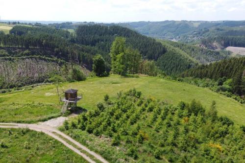 an aerial view of a grassy hill with a tower on it at La Harde 31 pers Malmedy, vue, wellness, jardin in Malmedy