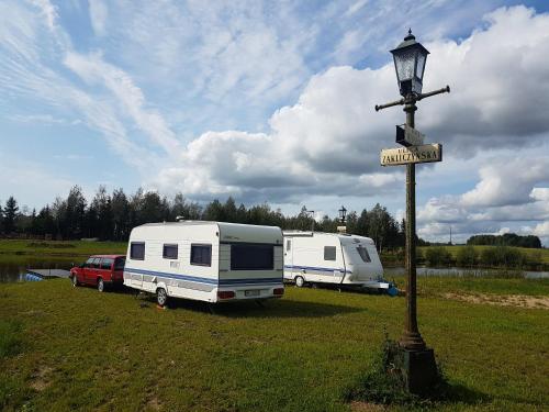 two rvs parked in a field with a street sign at Camping Konradówka in Olecko