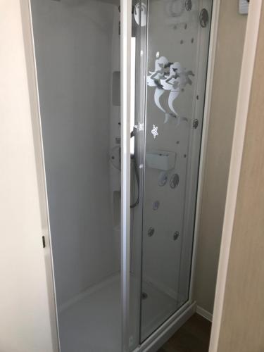 a shower with a glass door in a bathroom at Deluxe 3 bedroomed caravan on Marton Mere with CH DG and decking in Blackpool