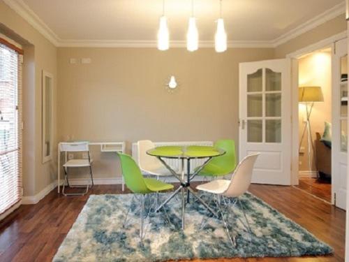 a dining room with a table and green chairs at Luxurious KC House in Dungannon
