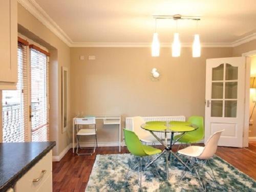 鄧甘嫩的住宿－Luxurious KC House，一间带桌子和绿色椅子的用餐室