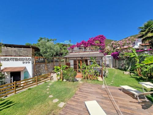 a backyard of a house with a wooden deck at Eco Hotel Montemerlo in Fetovaia
