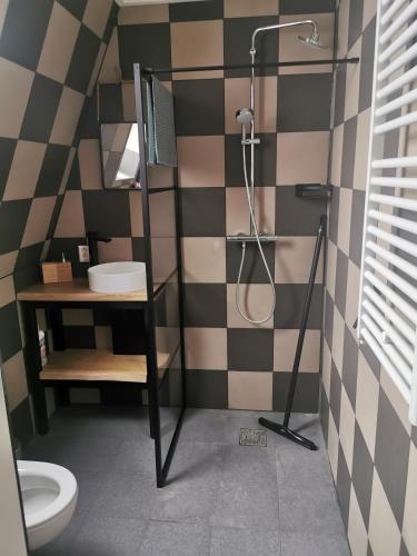 La salle de bains est pourvue d'une douche, d'un lavabo et de toilettes. dans l'établissement B&B Tasty, à Sneek