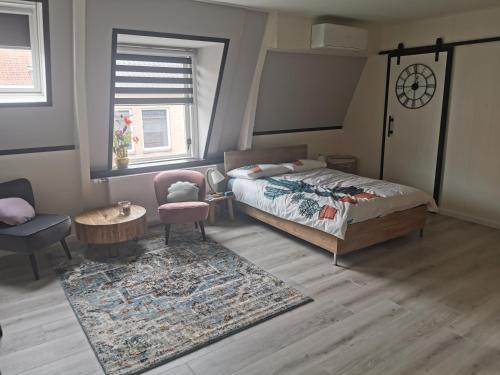 Schlafzimmer mit einem Bett, einem Tisch und einem Teppich in der Unterkunft B&B Tasty in Sneek