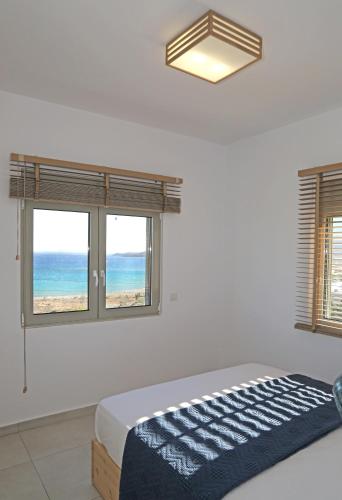 a bedroom with a bed and a view of the ocean at Aqua Bliss in Xerokampos