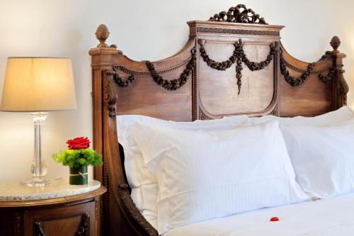 a bed with a wooden headboard and white pillows at Terrazze Navona in Rome