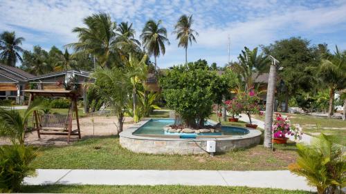 a fountain with a tree in the middle of a yard at Catsen Bungalows & Pool Phan Thiet in Phan Thiet