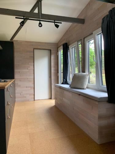a room with a bench with windows and a door at Tiny House by Lieblingsplatz in Sankt Peter-Ording