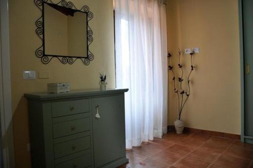 a room with a dresser and a mirror and a window at Manfredi Agriturismo in Savuto