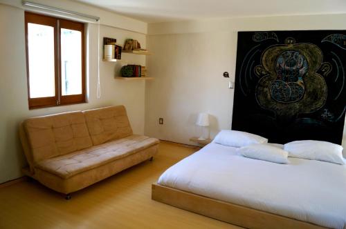 sypialnia z łóżkiem i kanapą w obiekcie Kuku Ruku Hotel w mieście Querétaro