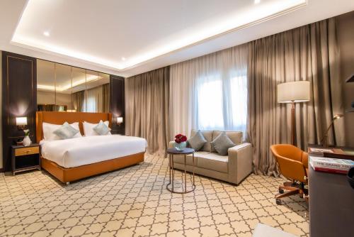 a large hotel room with a bed and a couch at Gardino Hotel & Residence in Riyadh