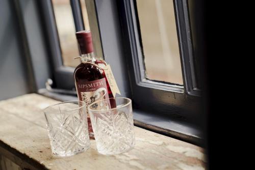 a bottle of wine and two glasses on a window sill at Bel and The Dragon at Red Lion Wendover in Wendover