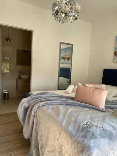 a bedroom with a bed and a mirror and a chandelier at Murter - Jezera Luxury Apartments in Jezera