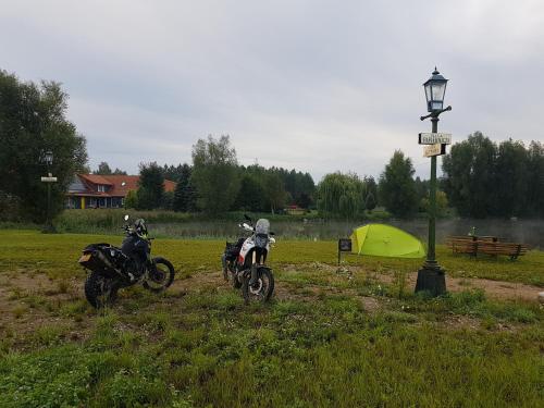two motorcycles parked in a field next to a tent at Camping Konradówka in Olecko