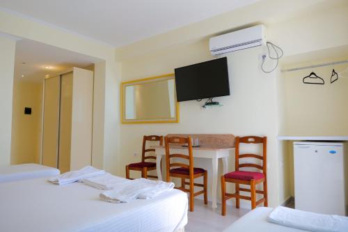 a room with two beds and a table and chairs at Republika Hotel in Sarandë