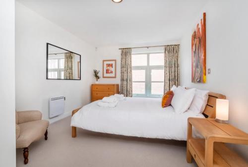 - une chambre avec un grand lit blanc et une chaise dans l'établissement City Apartments - John Walker House, à York