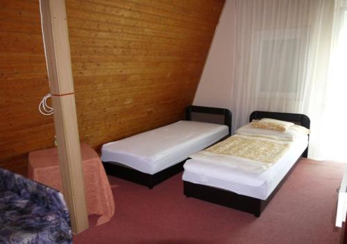 シオーフォクにあるMarika Vendégházの木製の部屋にベッド2台が備わる部屋