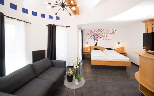 a living room with a couch and a bed at Berghotel Kristall in Idar-Oberstein