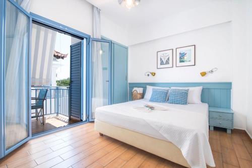 um quarto com uma cama grande e uma varanda em Saronis Hotel Agistri - Adults Only em Skala