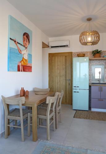 a dining room with a table and a painting on the wall at Aqua Bliss in Xerokampos