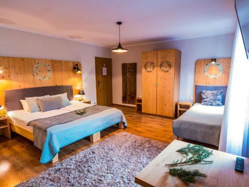 a hotel room with two beds and a table at Willa Pokusa in Szczawnica