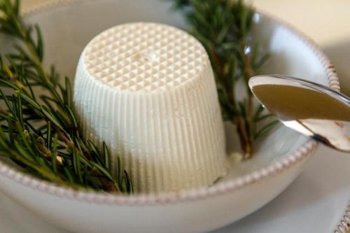 a white candle in a white bowl with a plant at PALAZZO FRANGIPANE in Salve