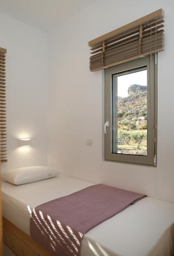a bedroom with a bed and a window at Aqua Bliss in Xerokampos