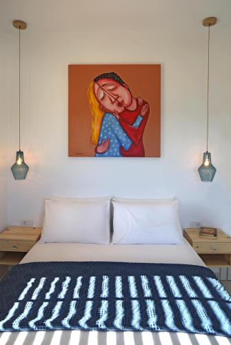 a painting hangs above a bed in a bedroom at Aqua Bliss in Xerokampos