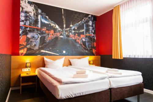 Schlafzimmer mit einem Bett mit Wandgemälde in der Unterkunft Altora Eisenbahn Themenhotel in Wernigerode