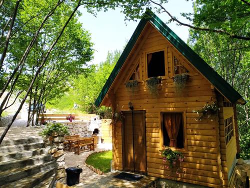 a log cabin with a table and a bench at Brvnara Fairy Tale in Cetinje