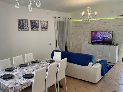a dining room with a table and a couch at Villa Bianca in Tertenìa
