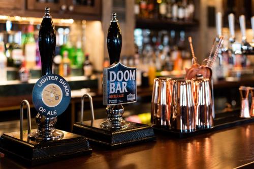 a bar with two bottles of beer on top of a counter at The Seaburn Inn - The Inn Collection Group in Sunderland