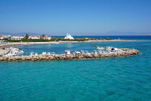a small island in the water with a group of boats at Saronis Hotel Agistri - Adults Only in Skala
