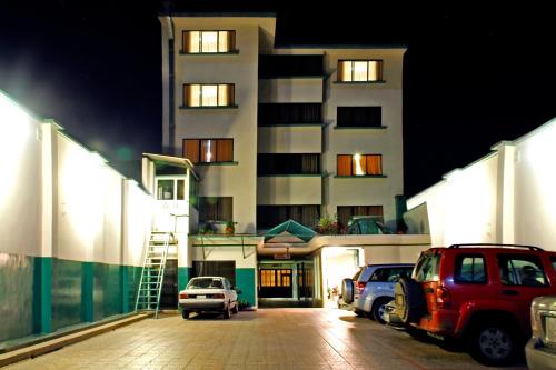 a parking lot in front of a building at night at Hotel Yanuncay in Cuenca