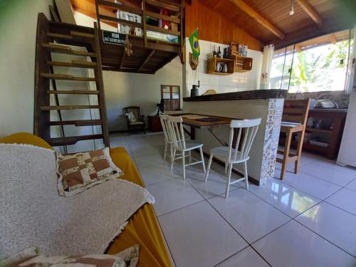 Loft praia Porto Belo في بورتو بيلو: مطبخ وغرفة معيشة مع طاولة وكراسي
