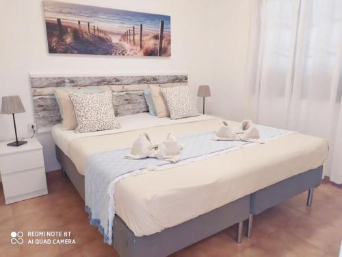 a large bed in a bedroom with two pillows at Bungalow King in Puerto del Carmen