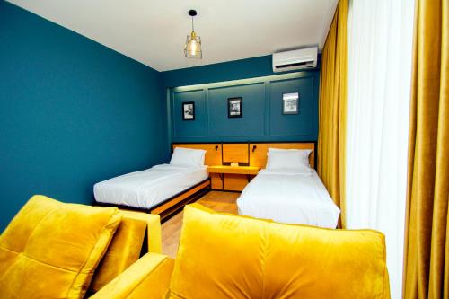 a small room with two beds and a couch at Borjomi Bridge Hotel in Borjomi