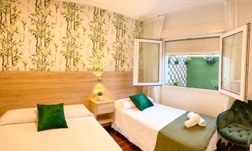 a hotel room with two beds and a window at PENSIÓN AUGAS QUENTES in Caldas de Reis