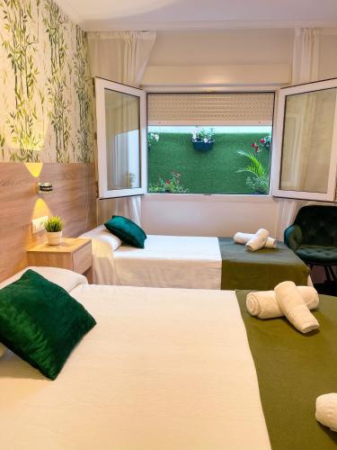 a hotel room with three beds and a window at PENSIÓN AUGAS QUENTES in Caldas de Reis