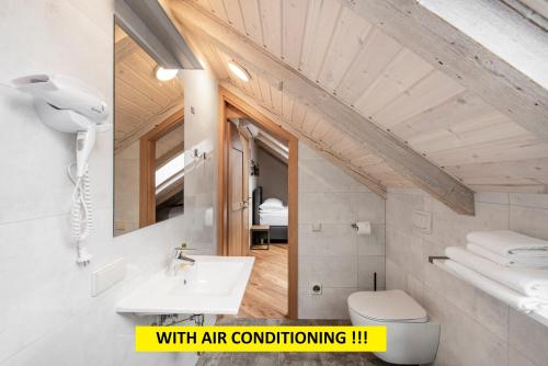 a bathroom with a sink and a toilet and a mirror at Small attic rooms in Kaunas old town in Kaunas