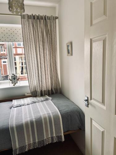 a small bedroom with a bed and a window at Lavender House in Edwinstowe