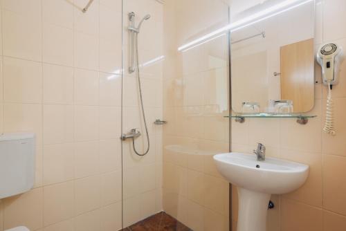 a white bathroom with a sink and a shower at Han Paprika Tureni in Tureni