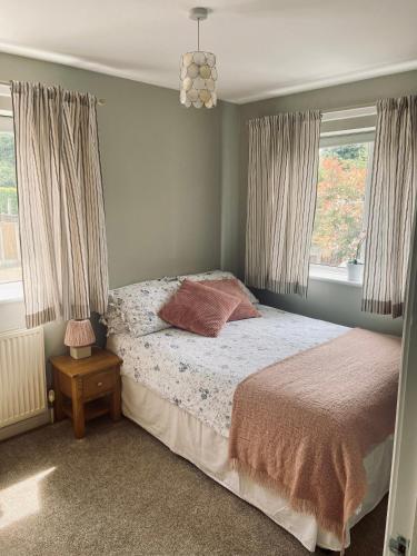 a bedroom with a bed and two windows at Lavender House in Edwinstowe