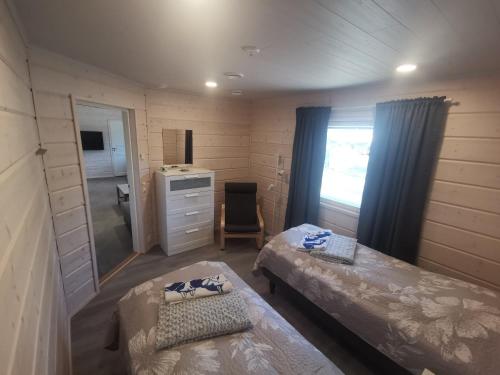 Habitación pequeña con 2 camas y espejo. en Maglelin Experience Lodge, en Kittilä